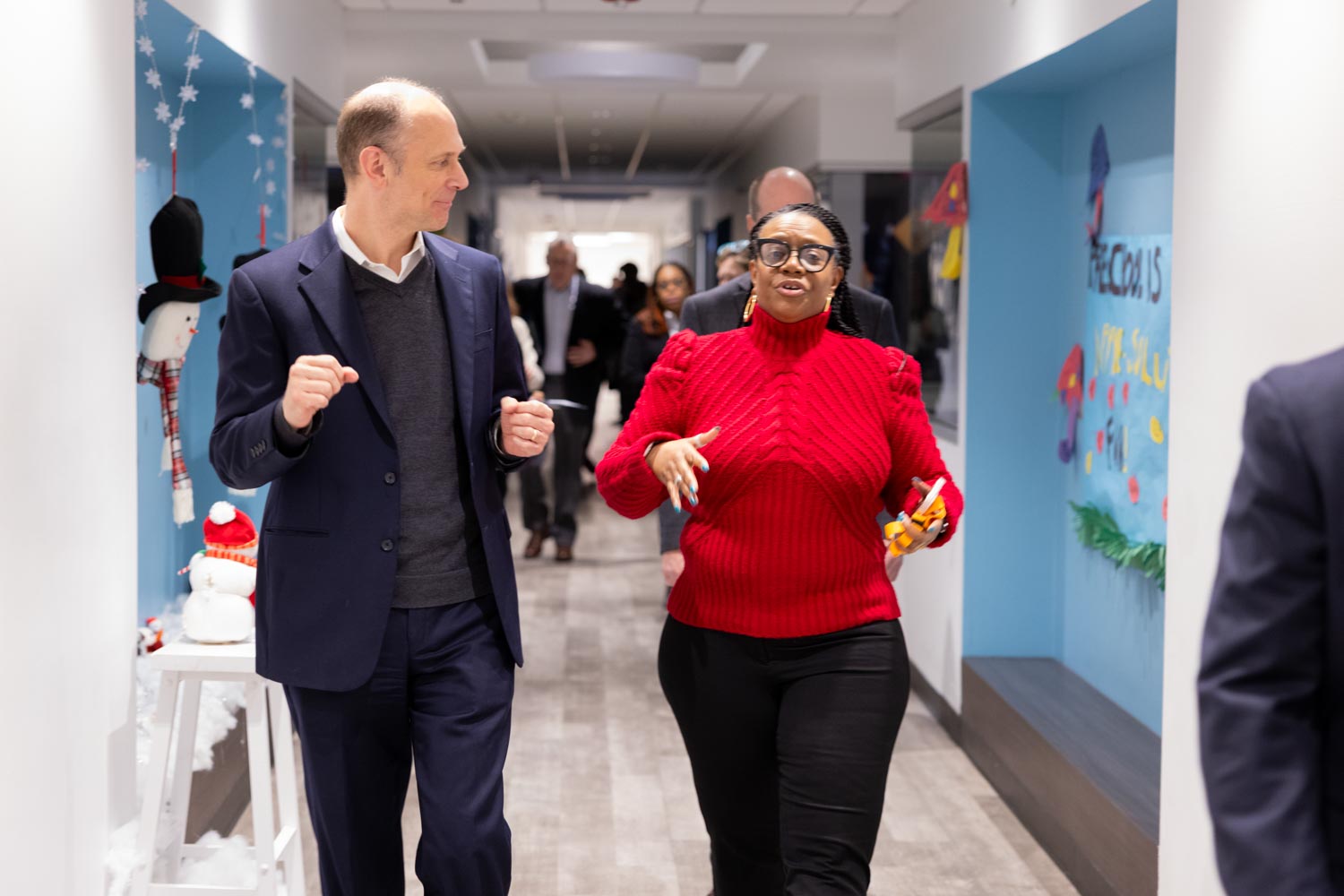 Austan Goolsbee, president and CEO of the Federal Reserve Bank of Chicago, walks down a hallway at Detroit's MiSide childcare center talking with Rhonda Mallory Burns, the center's Early Head Start/Head Start director. 