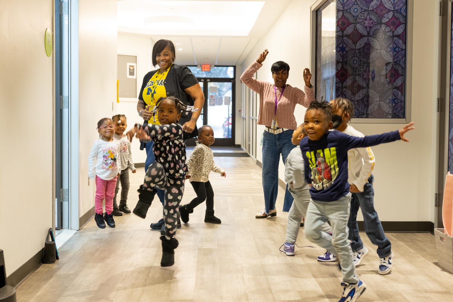 Young students and their teachers participate in a hallway dance break while learning the alphabet at MiSide, a childcare center in Detroit.