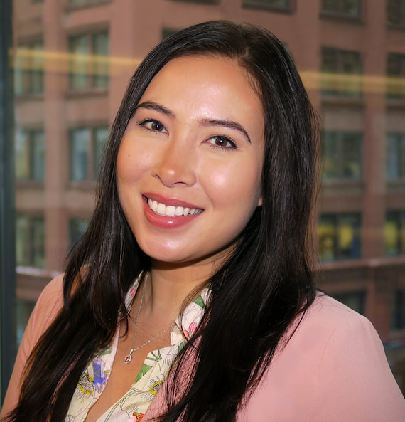 A smiling portrait of employee Missy Joslyn, with high rise buildings in the background.